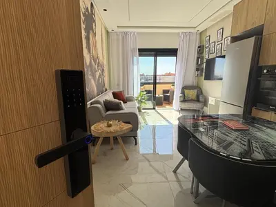 a living room with a glass table and a couch at Appartement Original et unique en plein hivernage pour familles in Marrakech