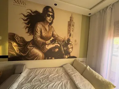 a mural of a woman riding a motorcycle on a wall at Appartement Original et unique en plein hivernage pour familles in Marrakech