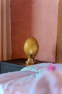 a gold lamp sitting on a table next to a bed at Modern Marrakech Garden Retreat Pool & Balcony in Marrakech