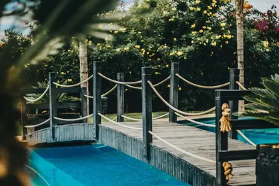 a wooden bridge over a pool in a park at Modern Marrakech Garden Retreat Pool & Balcony in Marrakech