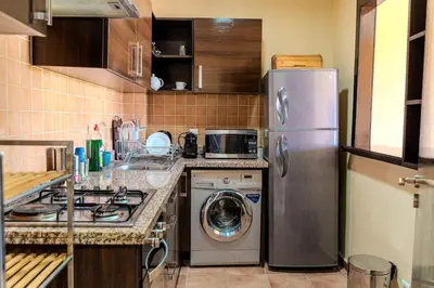 a kitchen with a refrigerator and a washing machine at Modern Marrakech Garden Retreat Pool & Balcony in Marrakech