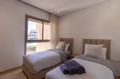 two beds in a room with a window at Marrakech prestigia in Marrakech