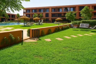 a building with a yard with chairs and a pool at Ground floor 2 elegant bedrooms with direct pool access in Marrakech
