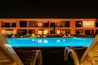 a hotel with a swimming pool at night at Ground floor 2 elegant bedrooms with direct pool access in Marrakech