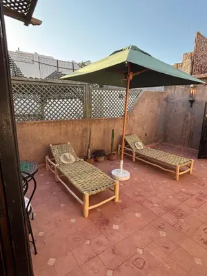 two chairs and an umbrella on a patio at Échappée onirique au cœur de la Cité Ocre in Marrakech