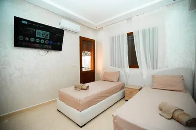 a room with two beds and a flat screen tv at New apartment rental in Marrakech