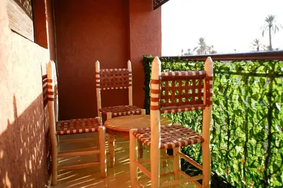 two chairs and a table and two chairs on a balcony at New apartment rental in Marrakech