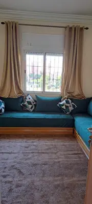 a blue couch in a room with a window at Menara Amandier in Marrakech