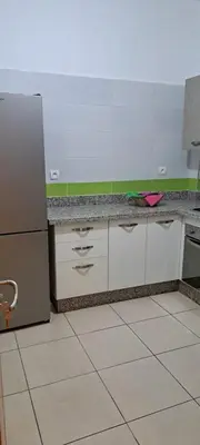 a kitchen with a refrigerator and a tile floor at Menara Amandier in Marrakech