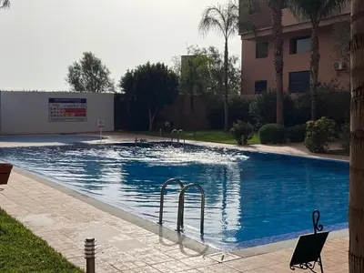 a large swimming pool in front of a building at Mimi MARRAKECH in Marrakech