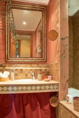 a bathroom with a sink and a mirror at Condo in the Heart of the Palmeraie, Pools in Marrakech