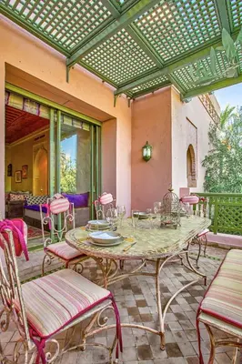 an outdoor patio with a table and chairs at Condo in the Heart of the Palmeraie, Pools in Marrakech