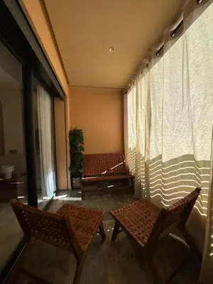 a balcony with two chairs and a window at Atlas-Si Cosy Appart Carré Eden in Marrakech