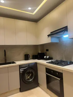 a kitchen with a washing machine and a stove at Atlas-Si Cosy Appart Carré Eden in Marrakech