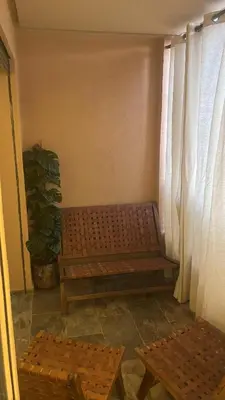 a bench in a room with curtains and a plant at Atlas-Si Cosy Appart Carré Eden in Marrakech