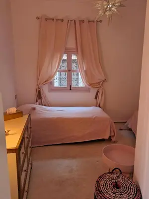 a bedroom with a bed and a window at Riad Paillettes in Marrakech