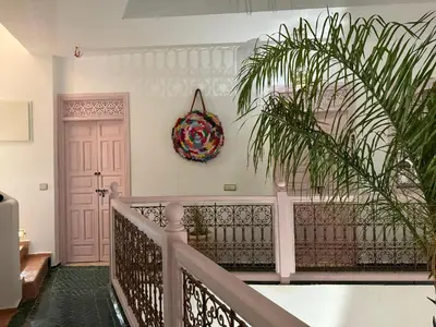 a hallway with a staircase with a plant and a door at Riad Paillettes in Marrakech