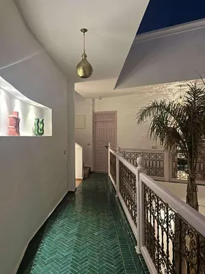a hallway with a staircase with a green floor at Riad Paillettes in Marrakech