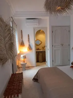 a bedroom with a bed and a bathroom at Riad Paillettes in Marrakech