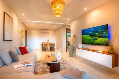 a living room with a couch and a tv at Luxueux appartement piscine coralia in Marrakech