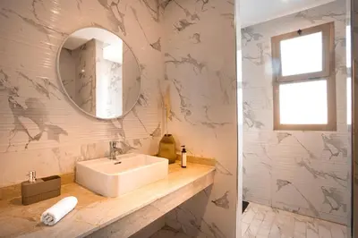 a bathroom with a sink and a mirror at Luxueux appartement piscine coralia in Marrakech
