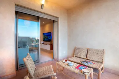 a living room with two chairs and a table at Luxueux appartement piscine coralia in Marrakech