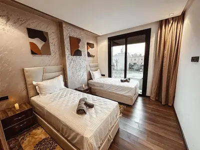a hotel room with two beds and a window at Luxury Apt near Majorelle & City Center in Marrakech
