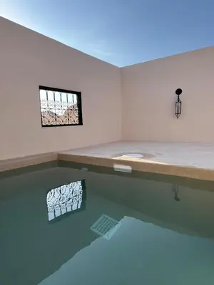 a room with a pool of water with a window at Riad Muvira in Marrakech