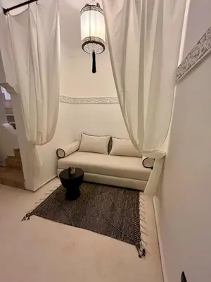a white couch sitting in a room with curtains at Riad Muvira in Marrakech