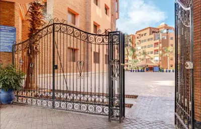 an iron gate in a city with a building at Sweet 1 Bed Room Appart in Marrakech