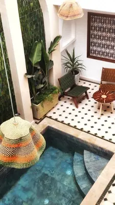 a pool in the middle of a living room with a umbrella at Riad Jô & Spa in Marrakech