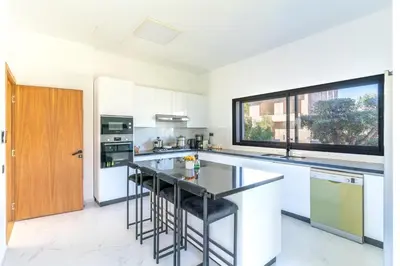 a kitchen with white cabinets and a glass counter top at splendid Villa King palace in Marrakech