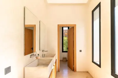 a bathroom with two sinks and two mirrors at splendid Villa King palace in Marrakech