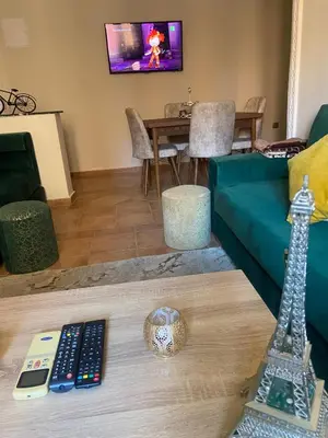 a living room with a couch and a television and a remote controls at Bel appartement 1er étage aux portes de gueliz in Marrakech