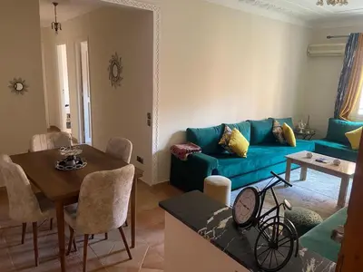 a living room with a blue couch and a table at Bel appartement 1er étage aux portes de gueliz in Marrakech
