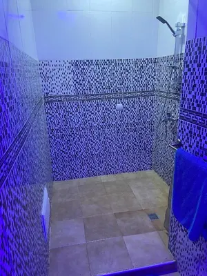 a bathroom with blue tiled walls and a shower at Bel appartement 1er étage aux portes de gueliz in Marrakech