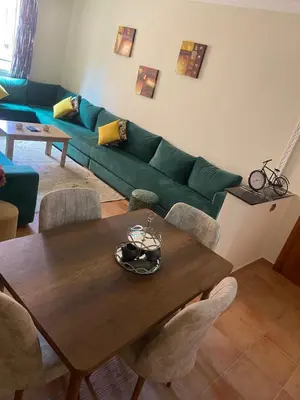 a living room with a green couch and a wooden table at Bel appartement 1er étage aux portes de gueliz in Marrakech