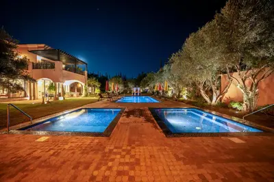 two swimming pools in a courtyard at night at Villa Juzyan Piscine-Jacuzzi-Pataugeoire-Pétanque in Marrakech