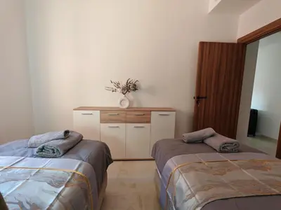 a room with two beds and a dresser in a room at Elegant Apartment with King-Size Bed, Premium Amenities, 5 Pools & Free Parking in Marrakech