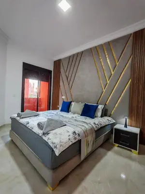 a bedroom with a large bed with blue pillows at Elegant Apartment with King-Size Bed, Premium Amenities, 5 Pools & Free Parking in Marrakech