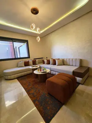 a large living room with a couch and a table at Jnane el Ali Gueliz in Marrakech
