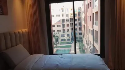 a bedroom with a bed and a large window at Jnane el Ali Gueliz in Marrakech