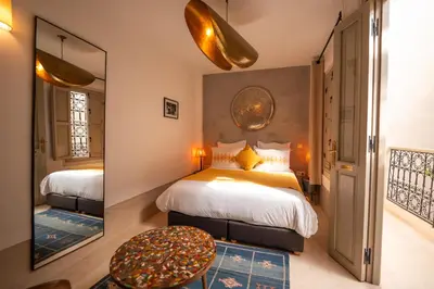 a bedroom with a large bed and a mirror at Riad Dar Amazonia in Marrakech