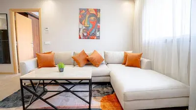 a living room with a white couch and a table at Stylish Gueliz Getaway, Terrace & Parking in Marrakech