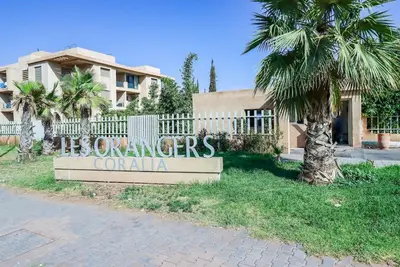 a sign in front of a house with a palm tree at New Charming apartment with swimming pool in Marrakech