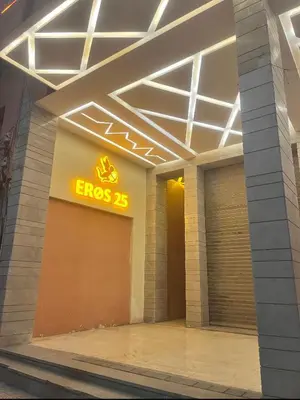 a building with a sign on the side of a garage at AquaEros - Appart Jacuzzi Carré Eden Marrakech in Marrakech