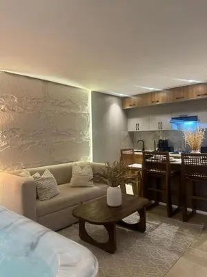 a living room with a couch and a kitchen at AquaEros - Appart Jacuzzi Carré Eden Marrakech in Marrakech