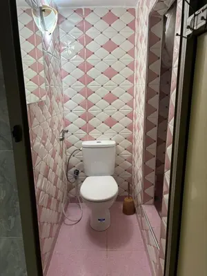 a pink tiled bathroom with a toilet in it at studio chez l'habitant in Marrakech
