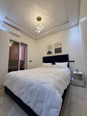 a bedroom with a large white bed with a ceiling at Appartement chic près de Guéliz Calme & confort à Marrakech in Marrakech