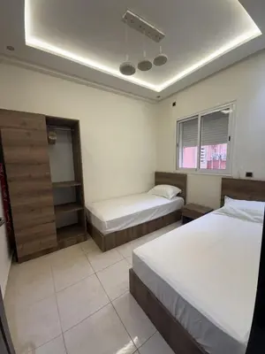 a hotel room with two beds and a mirror at Appartement chic près de Guéliz Calme & confort à Marrakech in Marrakech
